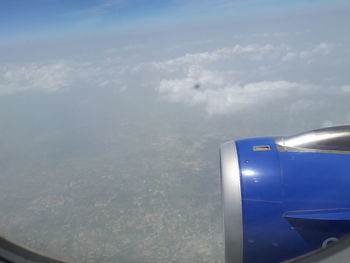 Close-up of airplane wing against sky