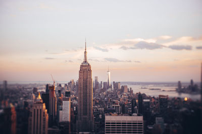 Modern buildings in city against sky during sunset