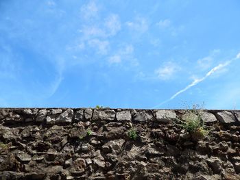 Low angle view of wall against blue sky