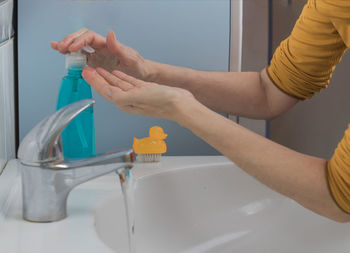 Midsection of man using mobile phone in bathroom