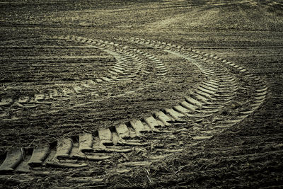 High angle view of tire tracks on field