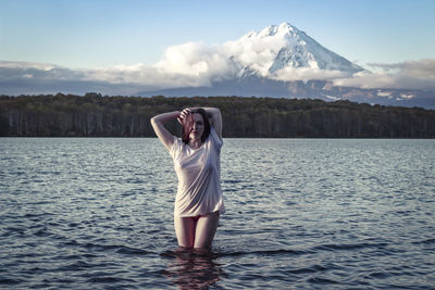 Full length of woman standing in lake against sky