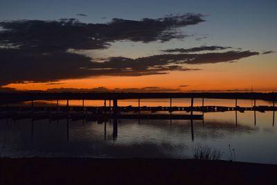 Silhouette pier on lake against sky during sunset