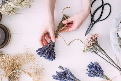 Hands of a florist woman at work. dry compositions of flowers and plants for the interior.