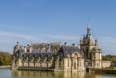 View of buildings at waterfront against sky