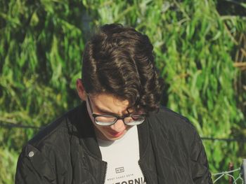 Close-up of boy looking down against plants