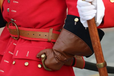 Midsection of man holding red umbrella