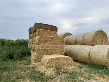 Hay bales on field against sky