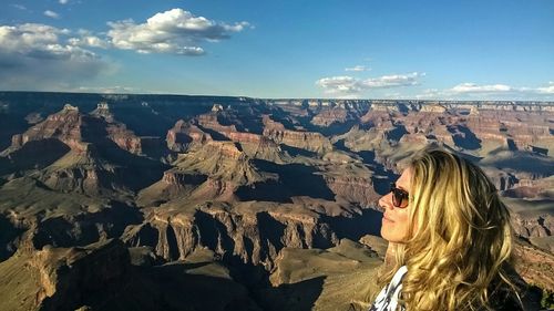 Woman standing on cliff against sky