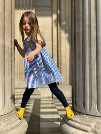 Cute girl standing on columns