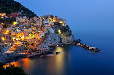 High angle view of townscape by sea against sky at night