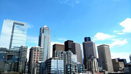 Low angle view of skyscrapers against blue sky