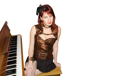 Portrait of a young woman sitting against white background