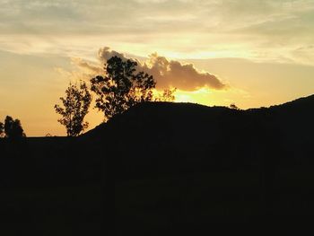 Silhouette landscape against sky at sunset