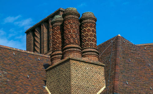 Low angle view of building against sky chimneys