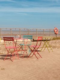 Chairs on beach against sky