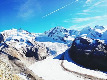 Scenic view of snowcapped mountains against blue sky