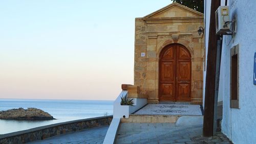 Entrance of building by sea against sky