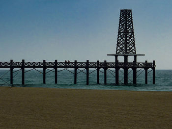 Gazebo by sea against clear blue sky