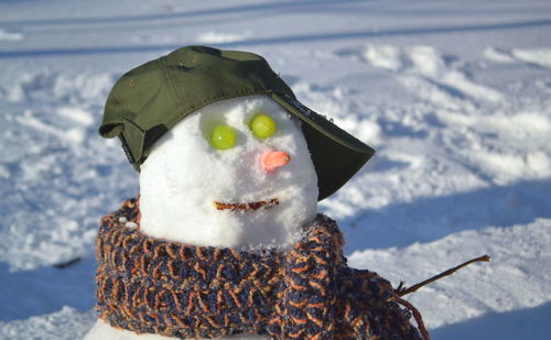 A s snowman with a funny hat and a scarf