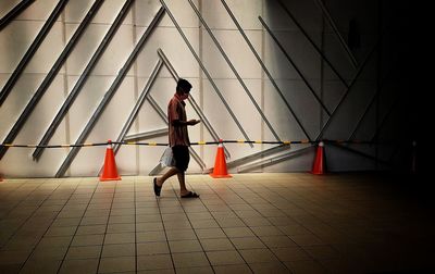 Side view of man walking on tiled floor