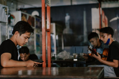 Side view of people sitting at home