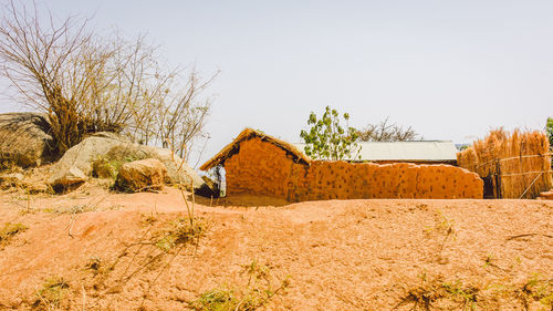 Clay house on field against clear sky in ruaha national park in tanzania