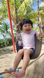 Portrait of boy swinging at playground