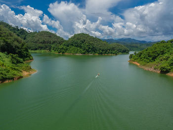 Scenic view of river amidst trees against sky