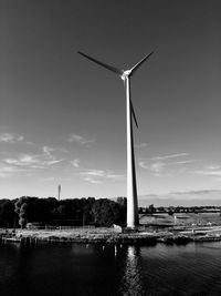 Wind turbines by lake against sky zandjik netherlands