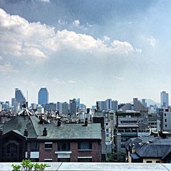 Buildings against cloudy sky