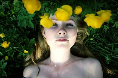 Portrait of young woman with yellow flowers