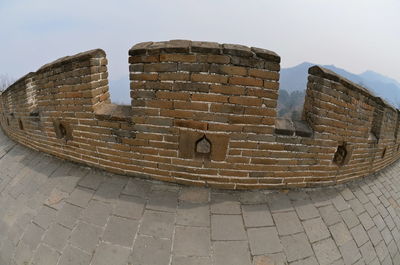 Low angle view of brick wall against sky