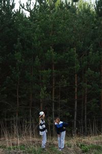 Rear view of men walking in forest