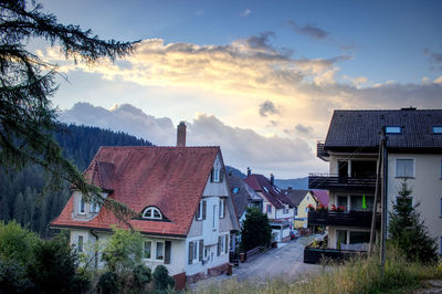 Houses and buildings in town against sky during sunset