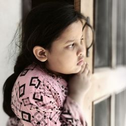 Cute girl looking away while standing at entrance