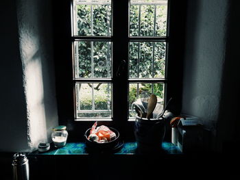 Spatulas in container on window sill at kitchen