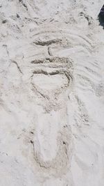 High angle view of text on sand
