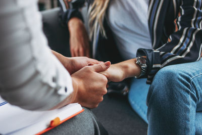 Midsection of couple holding hands