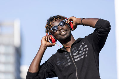 Full length portrait of young man holding camera