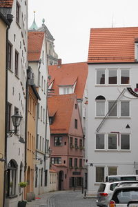 Cars on street amidst buildings against sky