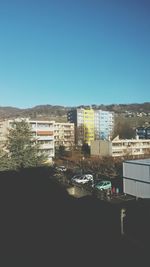 View of buildings against clear blue sky