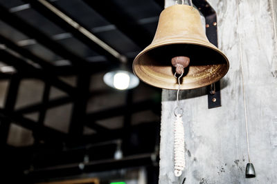 Low angle view of light bulb hanging on ceiling