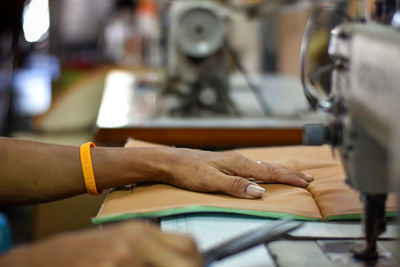 Cropped hands working on sewing machine
