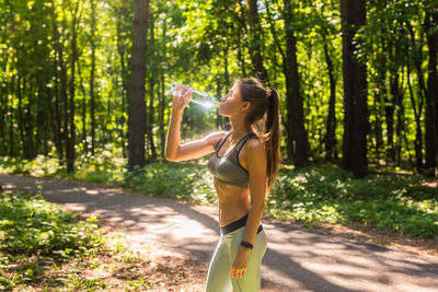 Young woman drinking water from bottle