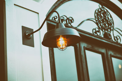 Low angle view of illuminated lighting equipment by window