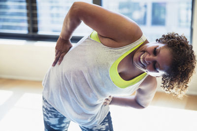 Happy woman with hands on hips exercising in yoga studio