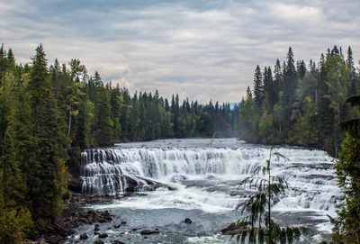 Scenic view of waterfall against sky