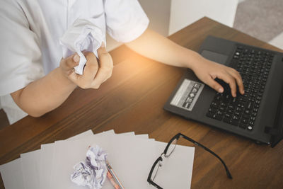 Midsection of man using mobile phone on table