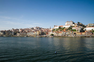 View of townscape by sea against sky